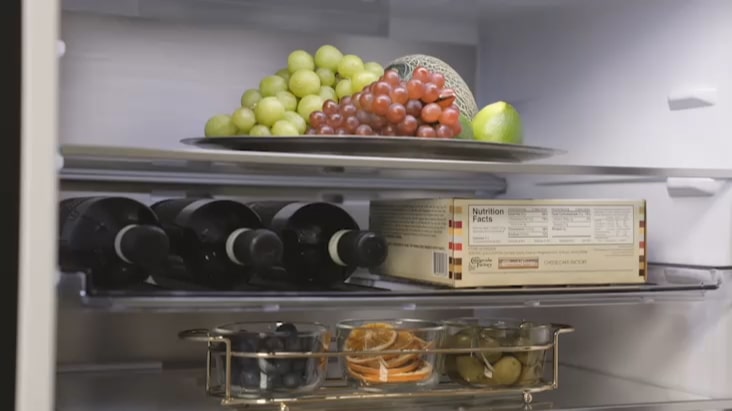 LG Fridge Freezer interior with wine rack storing bottles alongside fresh food items. LG Fridge Freezer interior with wine rack storing bottles alongside fresh food items.