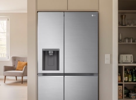 LG silver American-style fridge freezer built into the wall in a modern kitchen. The fridge has a large capacity with an integrated water and ice dispenser on the front.