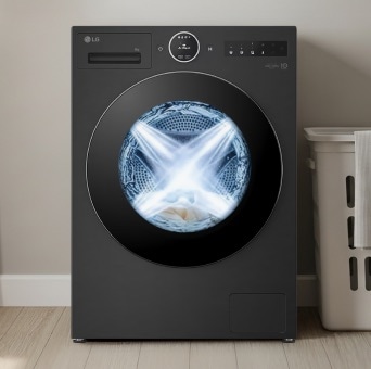 LG black washing machine in a modern utility room. A laundry basket is placed next to the machine, and the inside of the dryer is brightly lit and visible.