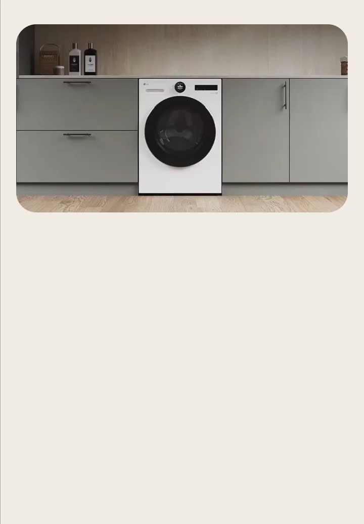 LG white washing machine, built into a grey storage cabinet in a modern utility room.