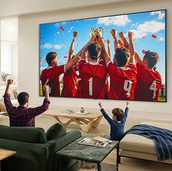 LG QNED evo AI QNED85 Mini LED Ultra Big TV is wall-mounted in a living room, displaying a sports victory celebration with vivid colors and refined picture quality across the wide screen as a family seated on sofas cheers together.