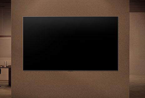 LG QNED evo AI QNED85 Mini LED is wall-mounted with the screen off, then turns on as a person approaches, using motion sensors to display an abstract swirling artwork.