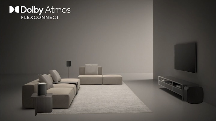 LG QNED evo AI QNED85 Mini LED with Sound Suite shows a wide room where the TV and wireless speakers are freely positioned, conveying immersive Dolby Atmos audio optimised for flexible speaker placement.