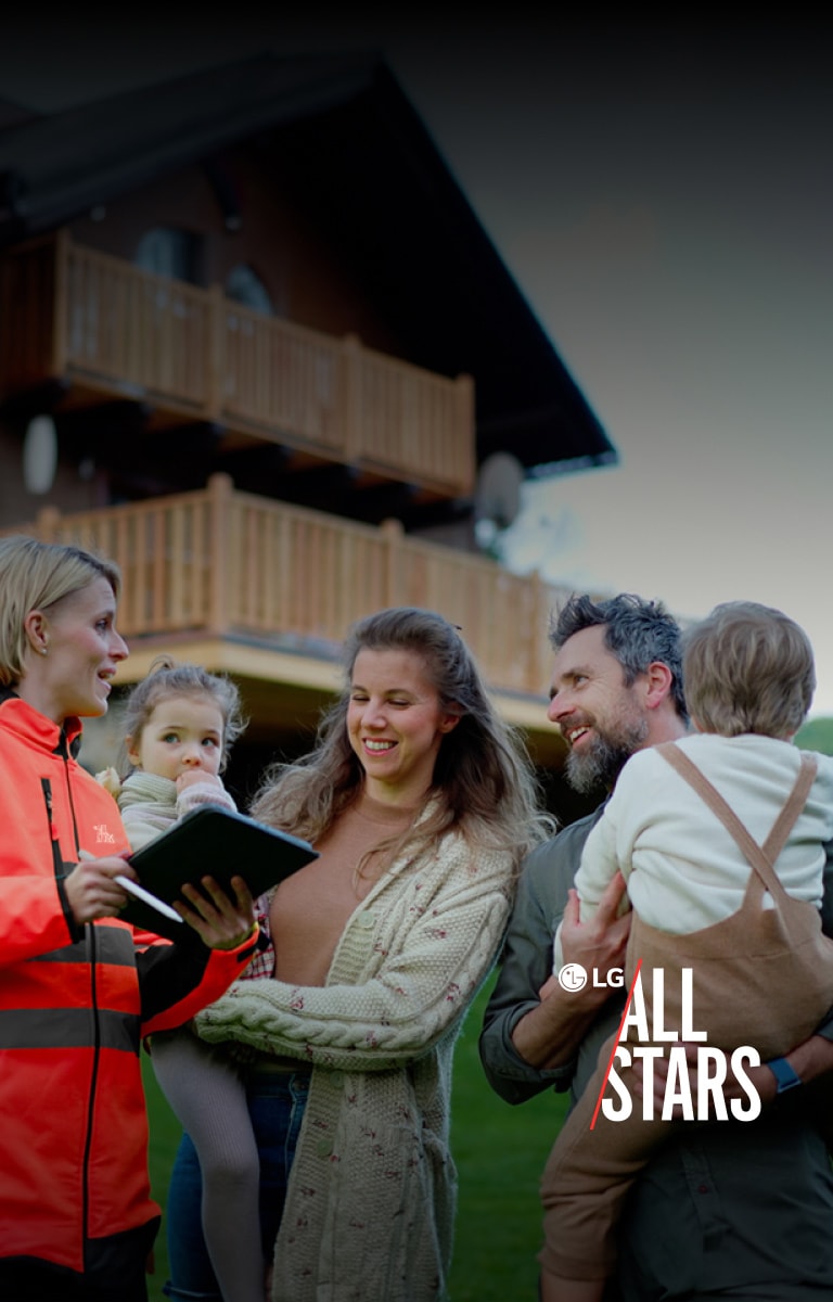 Eine 4 köpfige Familie mit zwei Kinder, hören einer Frau in einer roten Uniform zu. 