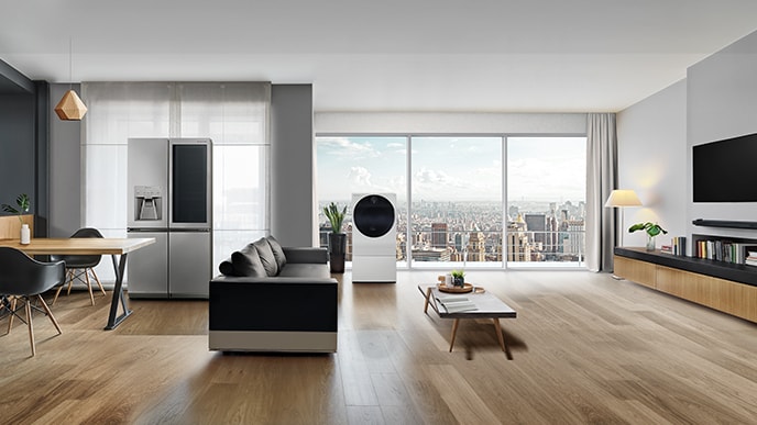 LG SIGNATURE Kühlschrank, Waschmaschine und OLED-Fernseher W sind im Wohnzimmer mit Blick auf die Stadt hinter dem Fenster ausgestellt.
