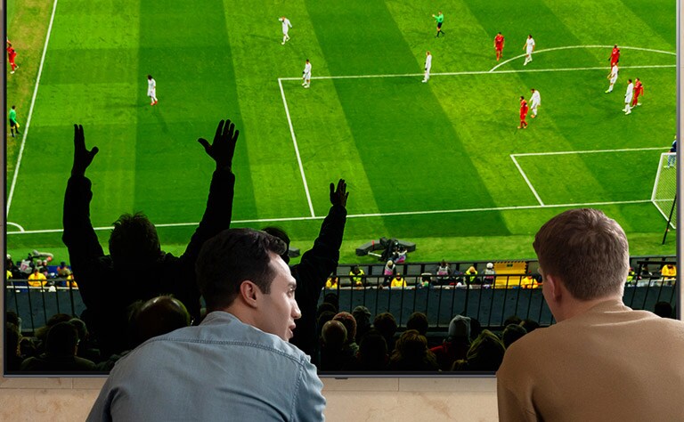 Zwei Männer sind von hinten zu sehen, während sie sich im Wohnzimmer auf einem NanoCell TV ein Fußballspiel mitverfolgen.