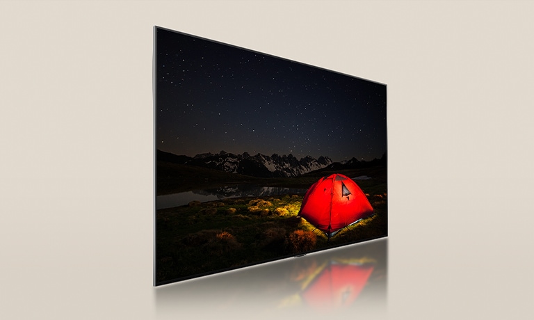 LG TV mit einem gedimmten Bildschirm, der eine dunkle Nacht mit einem leuchtend roten Zelt zeigt. Ein Panel mit blauer Hintergrundbeleuchtung wird von der Rückseite des Fernsehers getrennt. Kleine Dimm-Blöcke sind über das Panel verteilt. Dann werden das Panel und der Fernseher zusammengeführt, damit der Bildschirm heller und klarer wird.