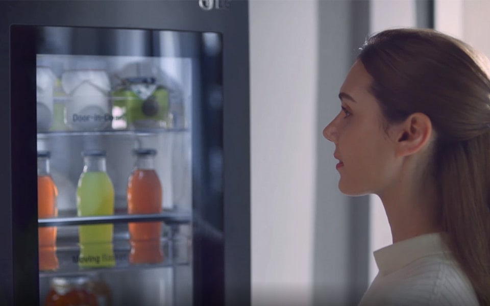 A woman looking into her LG refrigerator after using the knock system.