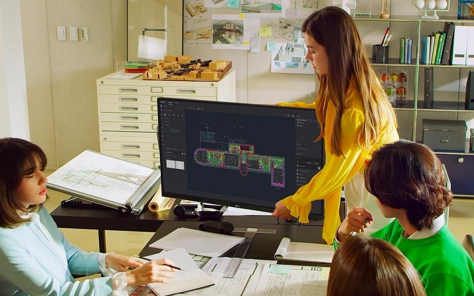 A woman sets the correct monitor height for her desktop display