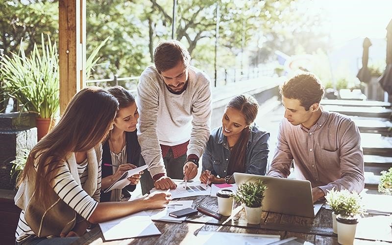 A group of colleagues look over some documents together, surrounded be greenery and clean air. That's our hope for the future as we work towards a more sustainable world | More at LG MAGAZINE