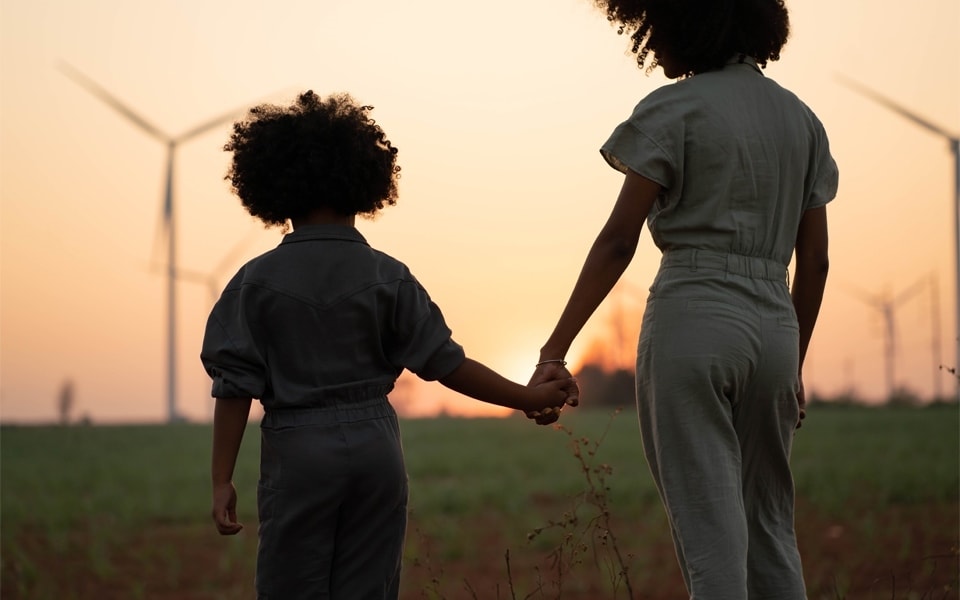 junge Verbraucher, die auf einem Feld mit Windrädern stehen