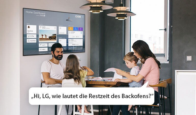 Eine Familie sitzt am Tisch und die Mutter fragt den Fernseher nach der Restzeit des Backofens.