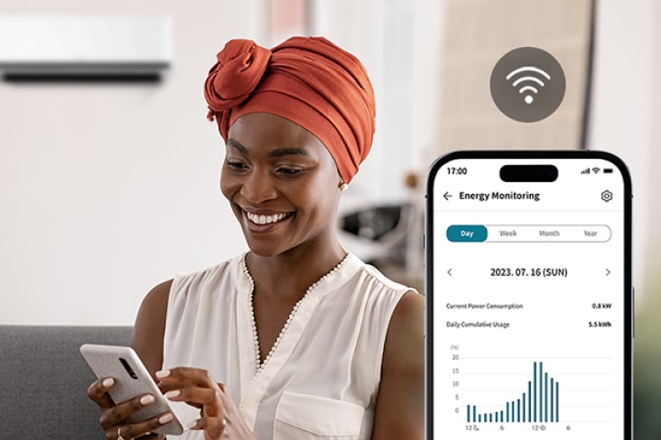 Woman using the LG ThinQ app with Energy Manager++ to monitor energy usage and view consumption graphs on her phone.
