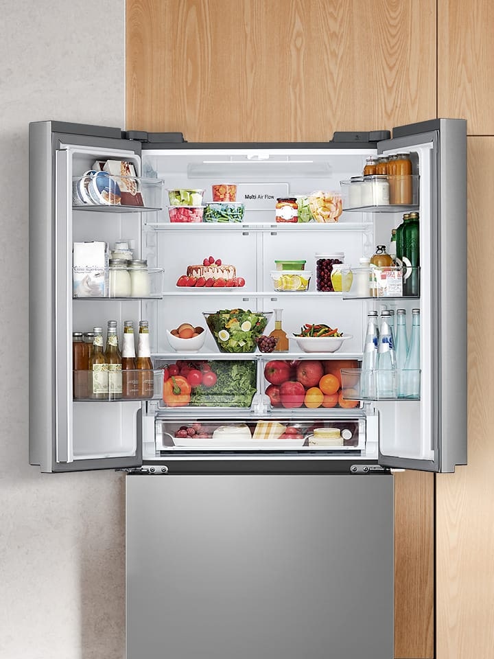 Kitchen interior with a lg french door refrigerator with an open door, showcasing fresh food inside.