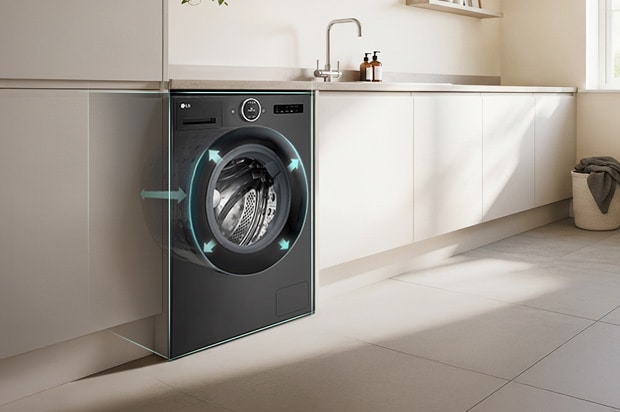 LG front load washing machine built into kitchen cabinetry. Arrows point outward from the drum to indicate size. A modern living room is visible next to the kitchen.