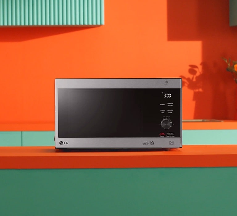 LG Neochef® microwave oven placed in bright orange and green modern design kitchen.