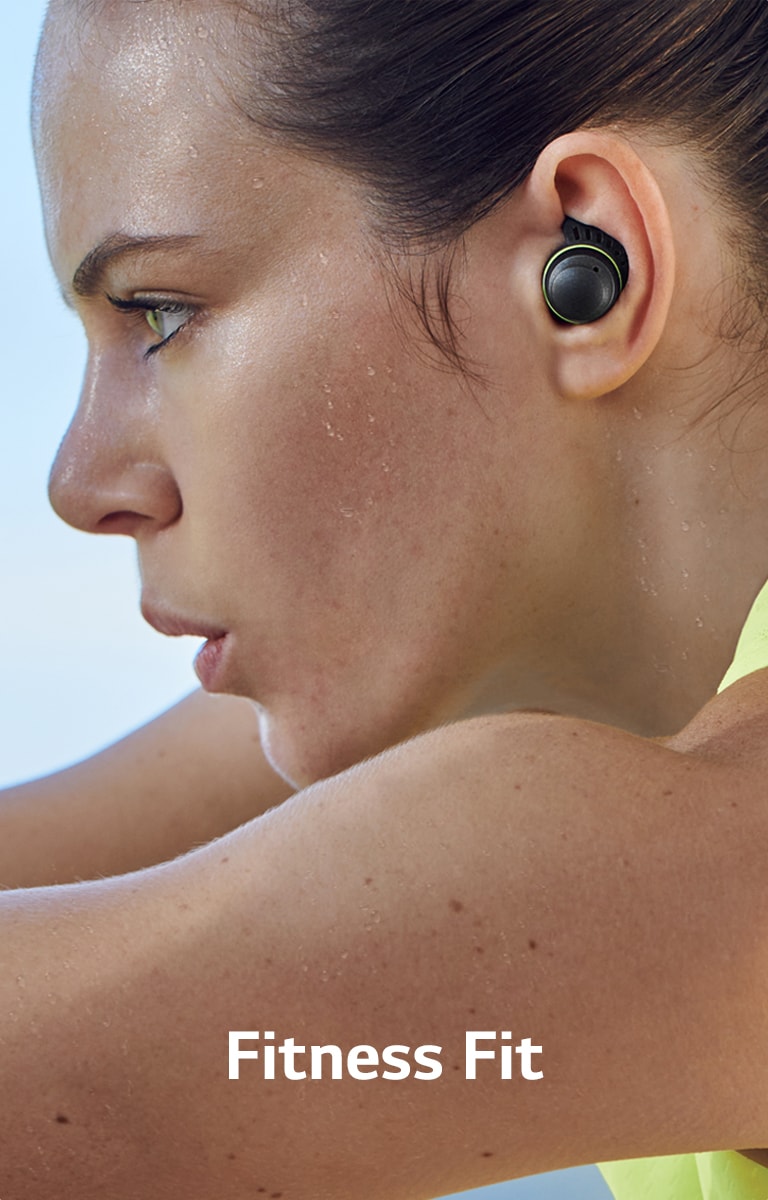 A woman is sweating and working out with TONE Free fit earbuds.