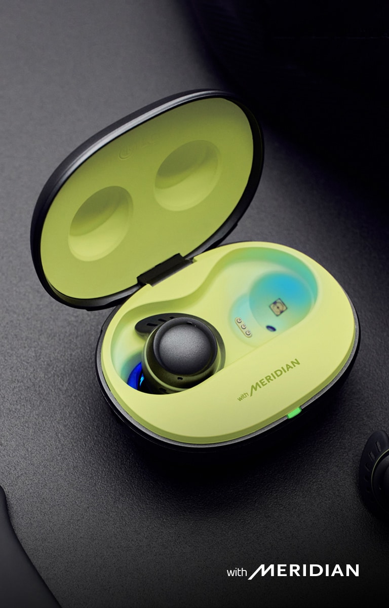 The TONE Free fit cradle is open, with the left earbud inside the case, and the right earbud outside. Meridian's logo is seen at the bottom of the image.