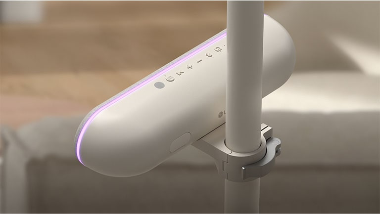 Rear view of the speaker attached to the LG StanbyME to highlight the adjustable cradle. The speaker's purple mood lighting is on.