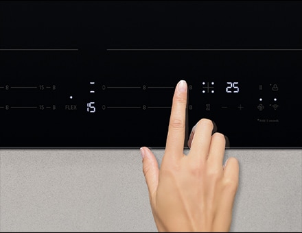 Touching the control panel of the induction cooktop.