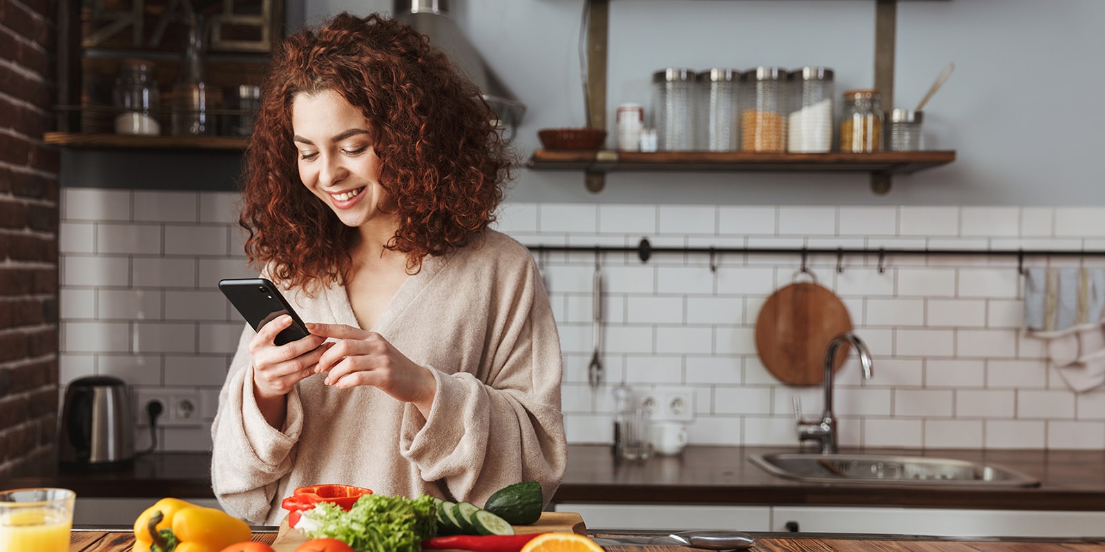 This is an image of a woman looking at a food recipe on her smartphone.
