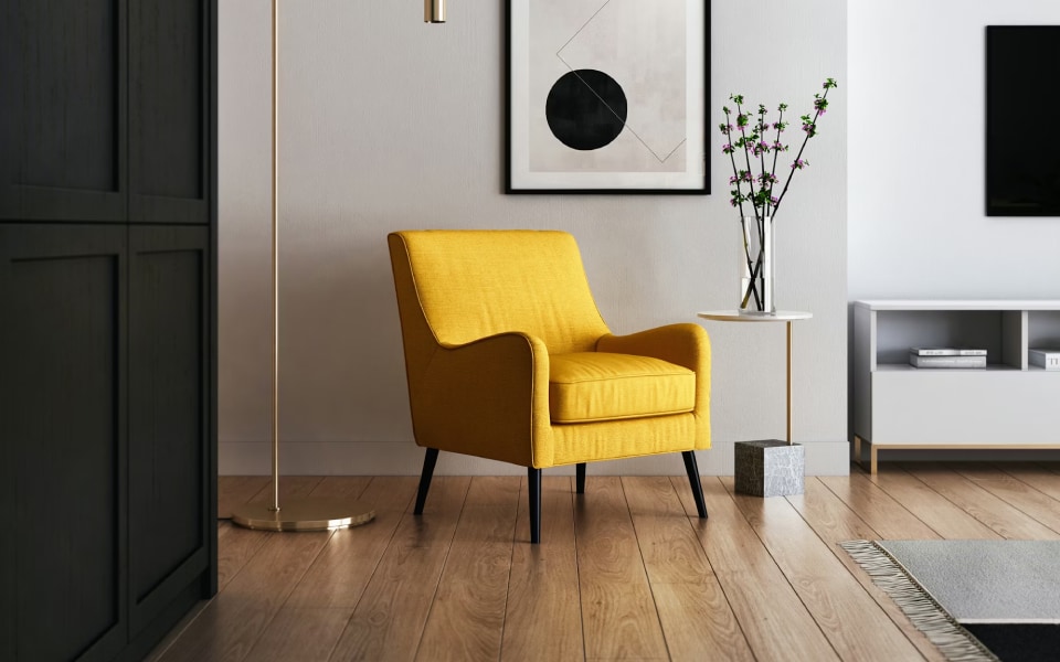 Modern living room in a smart home with a yellow armchair, geometric artwork, floor lamp, and TV.