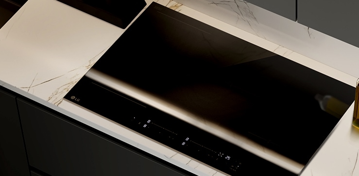 The glossy black glass finish of the induction cooktop.