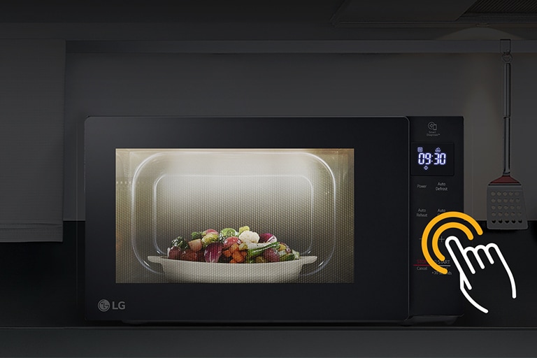 Microwave is placed within a darkened kitchen environment, while the internal LED lights in the microwave illuminate the food inside.