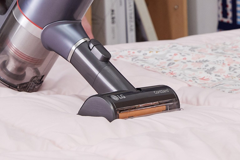 Three images in line: the first shows the vacuum vacuuming dirt from a hard surface, second shows vacuuming chips from a carpet, and the third shows the Power Punch on bedding.