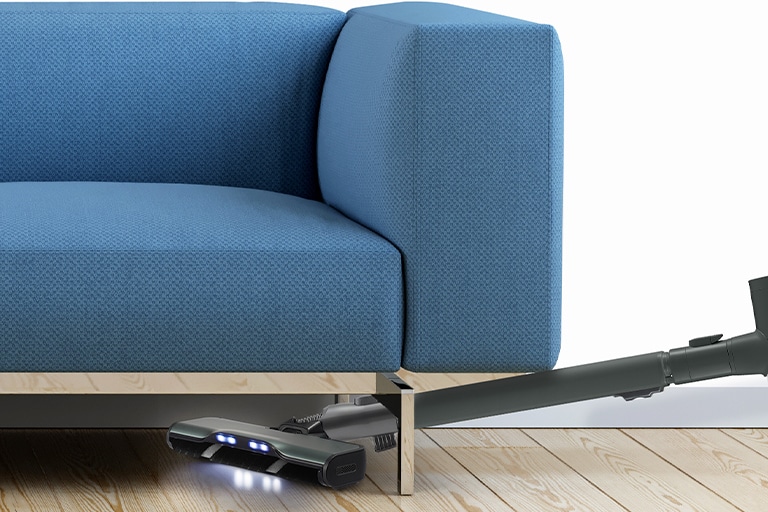 This image shows the Wide Slim nozzle cleaning easily, positioned within a narrow gap under the sofa while illuminating.