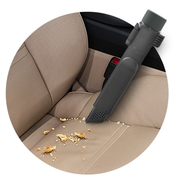 This image shows cleaning the car seat with a Crevice Tool.