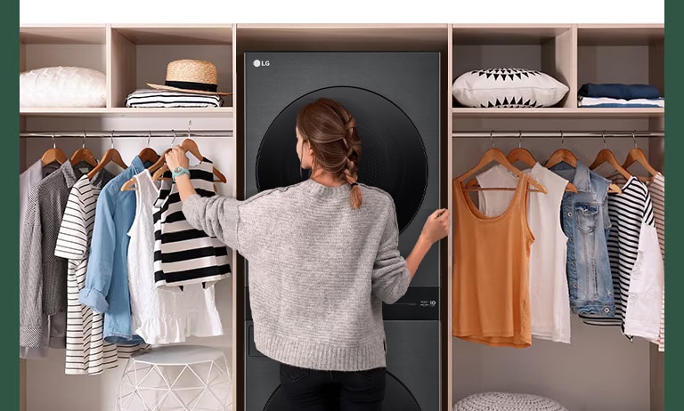 A WashTower is installed between the hangers, and a woman is choosing clothes in front.