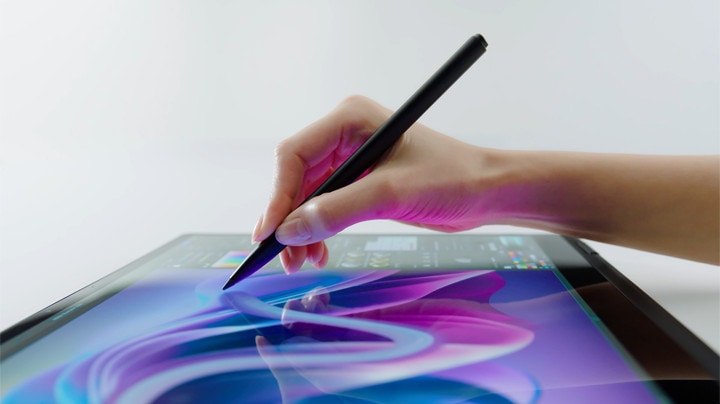 This video shows a woman's hand holding a stylus pen, gently touching the laptop screen in tablet mode to draw smoothly.