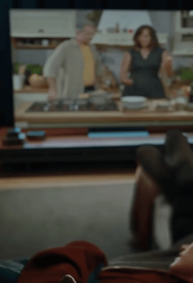 A man and a woman are on the sofa, watching a soccer broadcast on an LG TV in the living room. The scene transitions, and the man and woman are hugging. The camera focuses on the LG XBOOM next to them.