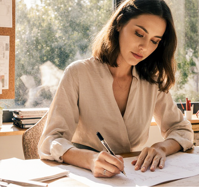 Consultora de interiores olhando um livro de design em um escritório bem iluminado.