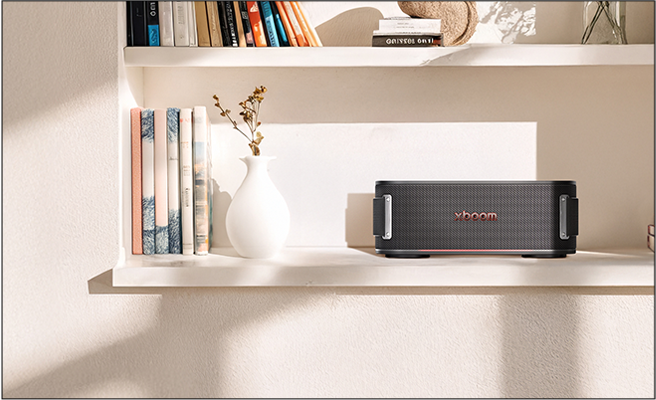 Ana aproveitando a leitura com uma caixa de som na área de leitura criada após a consultoria de interiores