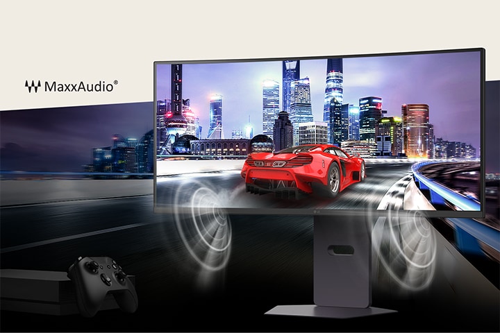 Um carro de corrida vermelho acelera pela estrada contra o pano de fundo de uma cidade com belos e altos edifícios, com um monitor UltraGear à frente e um controle de jogo no canto inferior esquerdo. O som é reproduzido de forma dinâmica pelos alto-falantes MaxxAudio em ambos os lados do monitor.