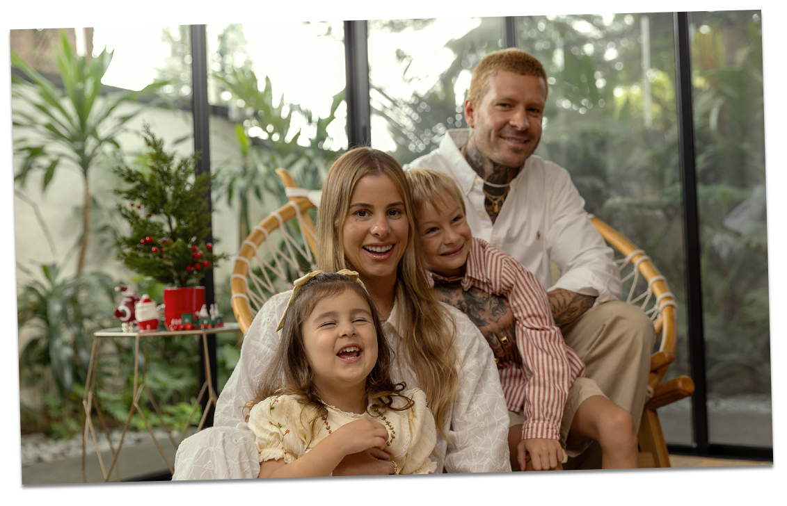 Família aproveitando uma aconchegante e memorável temporada de férias. Um casal e crianças estão sorrindo.