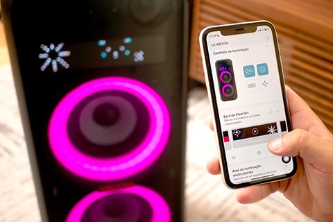 Homem operando o alto-falante LG XBoom com o aplicativo móvel. Ele está configurando a iluminação colorida e artes de pixel via aplicativo móvel.