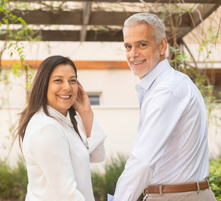 Luis e Rosana sorrindo ao ar livre, de mãos dadas.