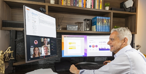 Luis trabalhando em home office com o monitor LG UltraWide e Ergo DualUp.