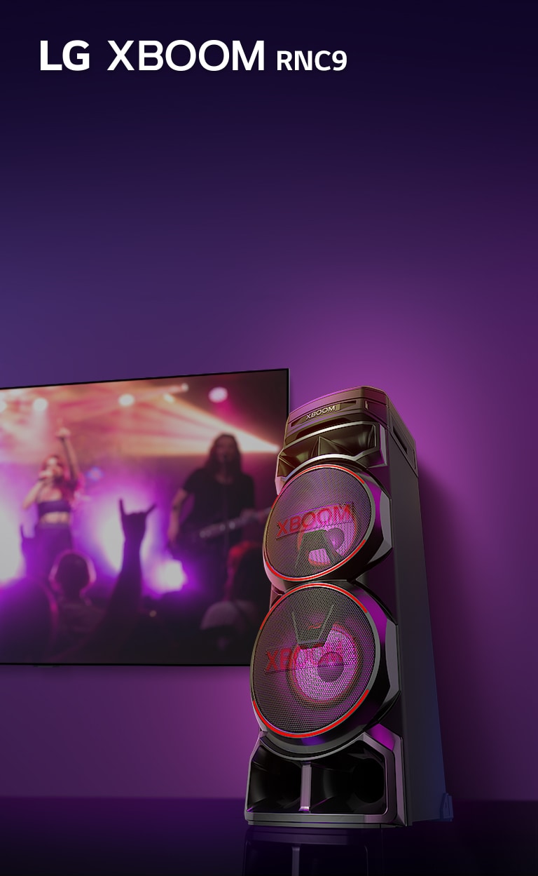 Uma visão de baixo ângulo do lado direito do LG XBOOM RNC9 contra um fundo roxo. A luz do XBOOM também é roxa. E uma tela de TV exibe uma cena de concerto.