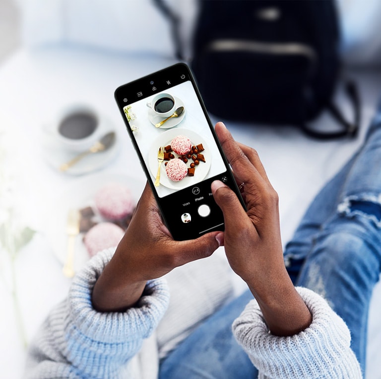 Mulher sentada no sofá tirando uma foto.