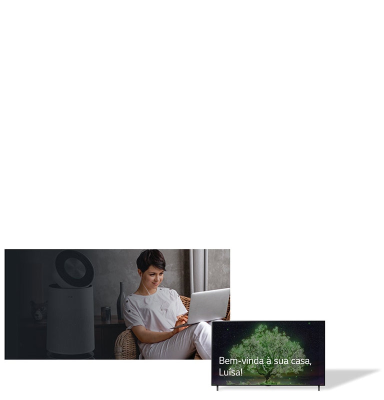 A imagem mostra uma mulher sentada em uma cadeira em casa, digitando em um laptop. Atrás dela, está um purificador de ar. Ao lado dela, está uma TV de tela plana exibindo as palavras “Welcome Home, Lisa!”