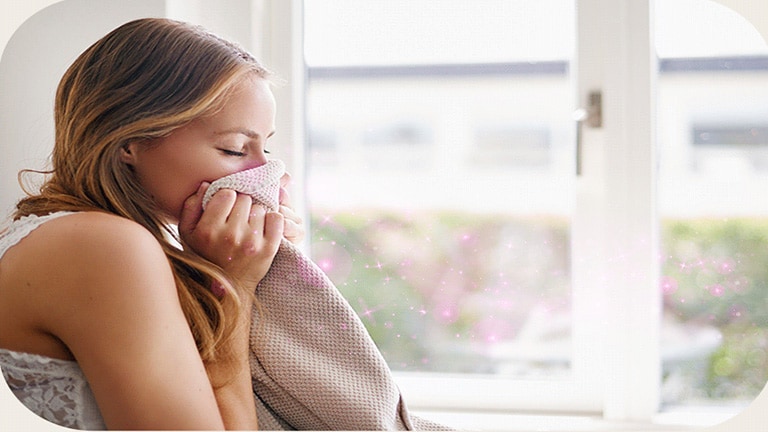 Imagem mostra mulher usufruindo da aromatização de roupas do Styler.