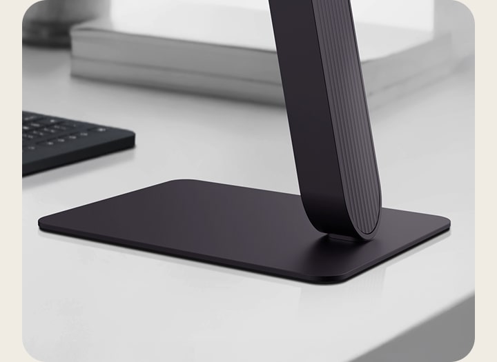 Vista em close do suporte do monitor LG UltraGear em uma mesa moderna.