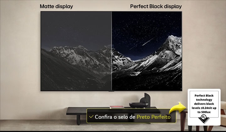 Sala de estar com uma LG OLED TV montada na parede. A TV exibe uma cadeia de montanhas contra um céu escuro e estrelado. Esta cena está dividida ao meio. Um lado mostra uma versão mais opaca e acinzentada da paisagem, denominada Tela desbotada. Do outro lado, há uma imagem mais agradável, com uma faixa dinâmica maior de pretos e brancos. Esta é a tela denominada Preto perfeito. O logotipo de certificação também é visível: a tecnologia Preto perfeito oferece níveis de preto menores ou iguais a 0,24 nit até 500 lux. Há um balão de texto ao seu lado que diz: verifique a marca de certificação Preto perfeito.