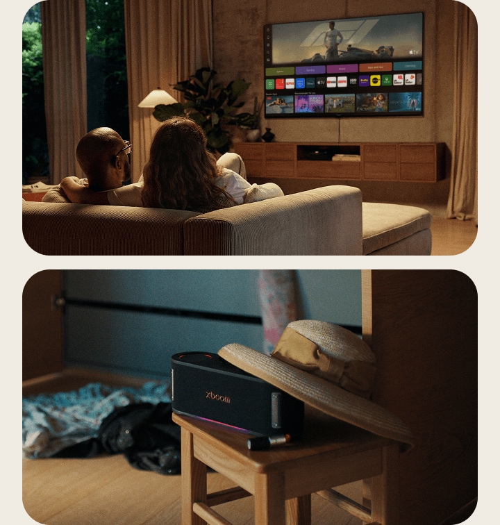 Uma caixa de som LG xboom AI sobre uma mesa lateral, ao lado de um casal relaxando no sofá assistindo LG Channels na LG AI TV.