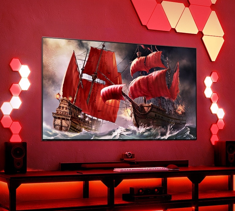 A TV QNED está colocada numa sala de jogos vermelha decorada com várias peças de iluminação.   A tela da TV mostra dois navios piratas no mar agitado