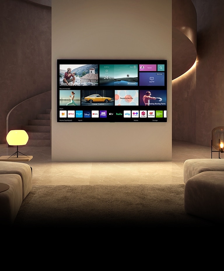 Há uma TV pendurada numa sala de estar luxuosa. A TV é ligada e mostra a tela inicial enquanto o ambiente também fica mais iluminado